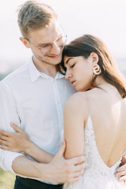 Gün batımında dışarıda mutlu bir çift. Güzel sanatlar Avrupa tarzında şık bir düğün. 