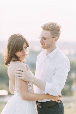 Gün batımında dışarıda mutlu bir çift. Güzel sanatlar Avrupa tarzında şık bir düğün. 