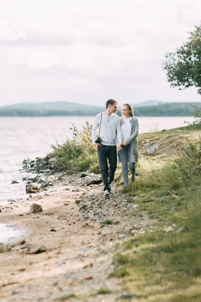 森の中を散歩する湖の上を歩く若いカップル — ストック写真