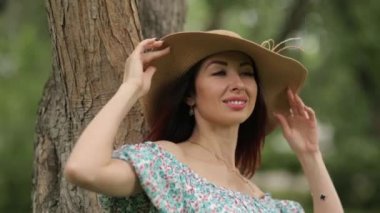 Güneşli fotoğraf çekimi. Yazlık parkta yürüyen şapkalı kız. 