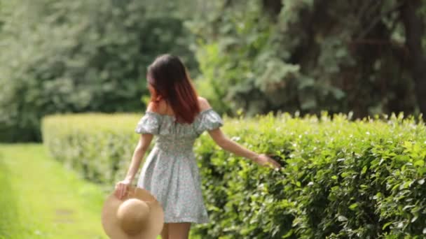 路地で晴れた写真撮影 夏の公園を歩く帽子をかぶった少女 — ストック動画