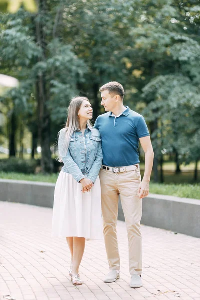 Happy people enjoy the good weather. Beautiful couple walking in the Park in the summer.