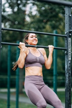 Barda eğitim ve barda pull-up. Oyun alanında güzel atletik kız. 
