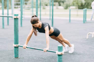 Şınav, egzersiz ve sokakta tahta. Oyun alanında güzel atletik kız. Şınav, egzersiz ve sokakta kalas.