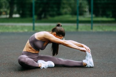 Eğitimden önce germe ve ısınma. Oyun alanında güzel atletik kız. 
