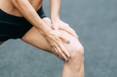  Ayaklar ve bağlama ayakkabı bağcıkları dışarıda oturuyor. Oyun alanında güzel atletik kız.