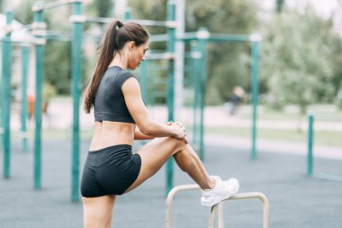  Doğada İsveç duvarında egzersizler. Oyun alanında güzel atletik kız.