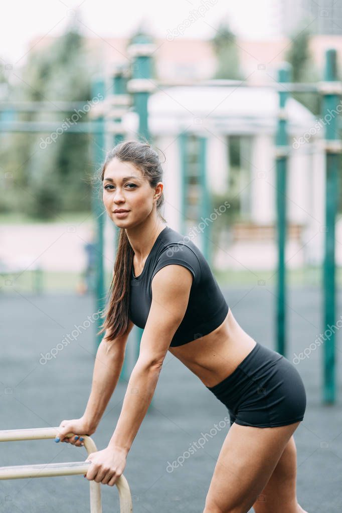  Exercises on the Swedish wall in nature. Beautiful athletic girl on the Playground.