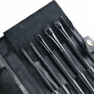 Makyaj fırçalı deri çanta. Bir çift siyah kaş fırçası.. 