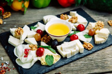 Bal ve fındıklı peynir. Taş bir tahtada peynir dilimlemek. 