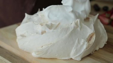 Pavlovs tatlısına krem şanti. Tatlıyı fırında pişirip, yemek tepsisine koyuyorsun..