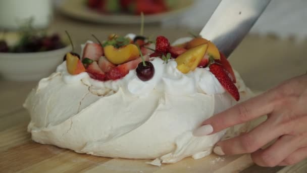 メレンゲ・パブロヴァスのデザートは、カリッとした皮と柔らかく、内側に光があり、果物やホイップクリームがトッピングされています。スライドデザート. — ストック動画