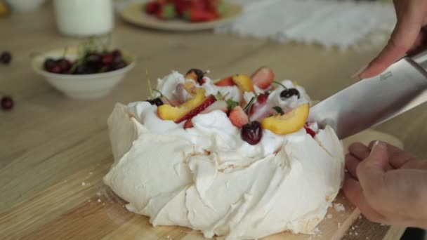 Десерт Meringue Pavlovas с хрустящей корочкой и мягким, светлым внутри, сверху фрукты и взбитые сливки. Слоистый десерт . — стоковое видео