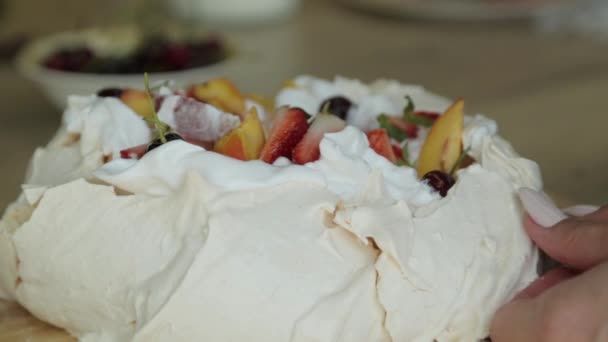 Meringue Pavlovas dessert met een knapperige korst en zachte, lichte binnenkant, topped fruit en slagroom. Gesneden dessert. — Stockvideo