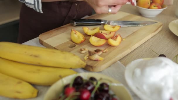 Ruce žena řeže hrušku na dřevěné desce vegetariánská složka vařit zralé ovoce deska vaření jídlo čerstvé zdravé — Stock video