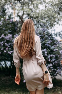 Leylak çiçekli lüks kadın. Parkta gülümseyen kız..