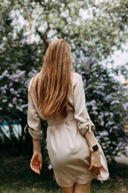 Leylak çiçekli lüks kadın. Parkta gülümseyen kız..