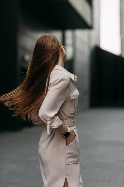 Heureuse femme d'affaires avec les bras croisés appuyé sur un mur. Sourire fille sur la rue. — Photo