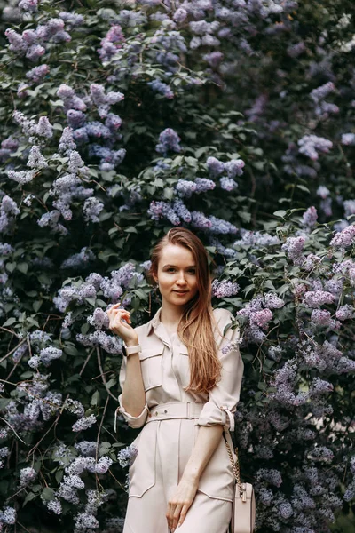 Mujer de lujo con flores lila. Sonrisa chica en parque al aire libre . —  Fotos de Stock