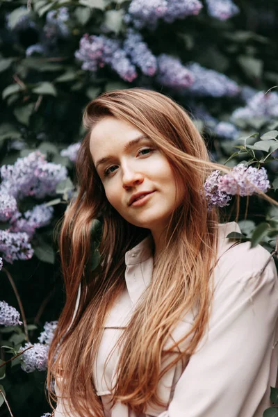 Mujer de lujo con flores lila. Sonrisa chica en parque al aire libre . — Foto de Stock