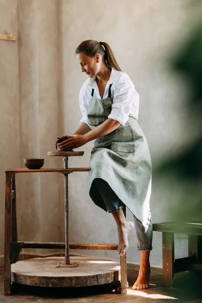 Όμορφη εμπνευσμένη σέξι ελκυστική όμορφη κοπέλα με τζιν και πουκάμισο που εργάζονται σε ένα εργαστήριο μοντελοποίησης σε τροχό αγγειοπλαστικής χειροποίητη δημιουργικότητα γυναίκα τέχνη στην εργασία, χόμπι, κορίτσι ζωγραφισμένο με μπογιά και πηλό — Φωτογραφία Αρχείου