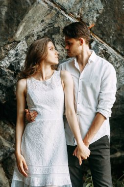 Öpüşmek üzere olan mutlu genç bir çift. Çiftler gün batımında doğada yürürler.