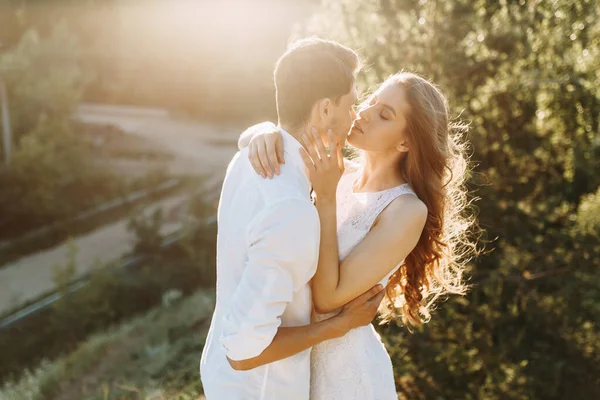 Um jovem casal feliz prestes a beijar-se. Caminhadas de casal na natureza ao pôr do sol . — Fotografia de Stock