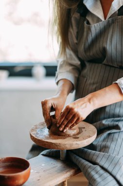 Çömlekçi çarkında çamurlu bir kızın elleri. Çömlek yapma süreci.