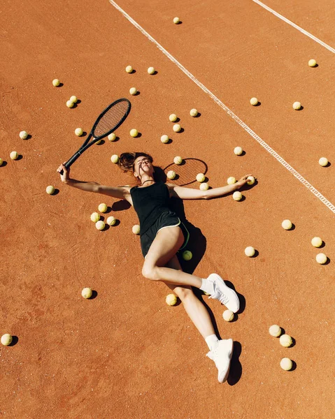 Mooie vrouwelijke atleet op de tennisbaan. Tennistraining, racket en bal, concept. — Stockfoto