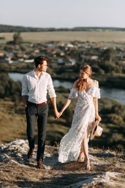 Boho tarzında güzel bir düğün çifti. Günbatımında Avrupa tarzı güzel sanatlarda düğün.