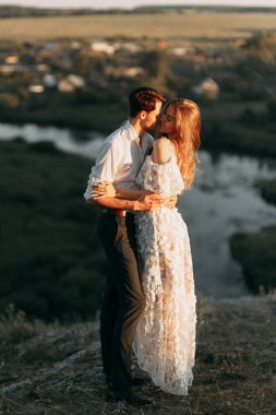 Boho tarzında güzel bir düğün çifti. Günbatımında Avrupa tarzı güzel sanatlarda düğün.