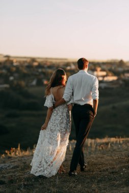 Boho tarzında güzel bir düğün çifti. Günbatımında Avrupa tarzı güzel sanatlarda düğün.