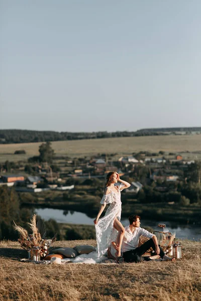 Gyönyörű esküvői pár a természetben boho stílusban. Esküvő az európai stílus képzőművészet naplementekor. — Stock Fotó