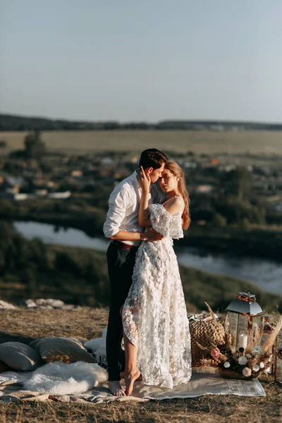 Casal bonito na natureza em estilo boho. Casamento no estilo europeu de fineart ao pôr do sol . — Fotografia de Stock