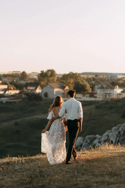 Gyönyörű esküvői pár a természetben boho stílusban. Esküvő az európai stílus képzőművészet naplementekor. — Stock Fotó