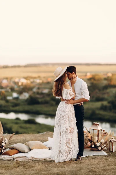 Pasangan pengantin yang cantik di alam dengan gaya boho. Pernikahan dalam gaya Eropa fineart saat matahari terbenam. — Stok Foto
