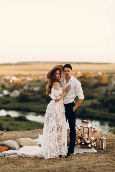 Boho tarzında güzel bir düğün çifti. Günbatımında Avrupa tarzı güzel sanatlarda düğün.
