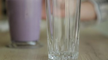 Yukarıdan yavaş çekimde karıştırılmış meyve püresi. Beyaz arka planda meyve çileği, muz ve yoğurt kullanarak..