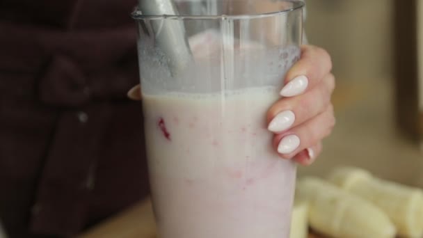 Smoothie misturado em câmera lenta de cima. Usando morangos de frutas, bananas e iogurte contra um fundo branco . — Vídeo de Stock