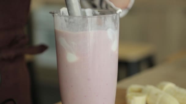 Smoothie gemengd in slow motion van boven. Gebruik van vruchtenaardbeien, bananen en yoghurt tegen een witte achtergrond. — Stockvideo