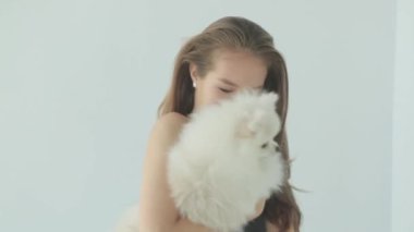 Sportif bir kız spor salonunda bir köpekle antrenman yapıyor. Küçük köpekli bir kızın portresi, gülümsüyor ve gülüyor..