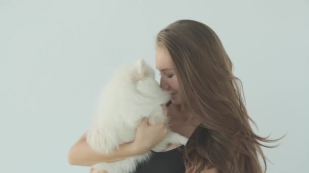 A sporty girl trains in the gym with a dog. Portrait of a girl with a small dog, smiling and laughing. — Stock Video