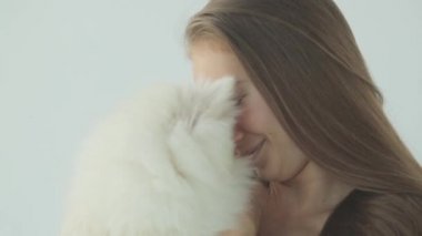 Sportif bir kız spor salonunda bir köpekle antrenman yapıyor. Küçük köpekli bir kızın portresi, gülümsüyor ve gülüyor..