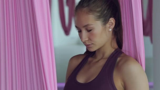 Una joven atlética hace yoga en una hamaca, ejercicios para la salud. Entrenamiento en el gimnasio con ventanas panorámicas. — Vídeo de stock