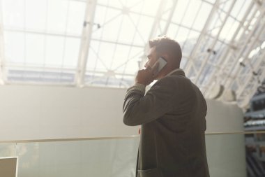 Takım elbiseli yakışıklı bir iş adamı ve sokakta telefonla konuşuyor. İş hayatında gülümseyen ve gülen genç bir adamın portresi..