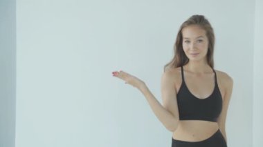 Makyajlı bir kızın yakın plan portresi. Kız gülümsüyor ve gülüyor, beyaz arka plandaki kameraya bakıyor..