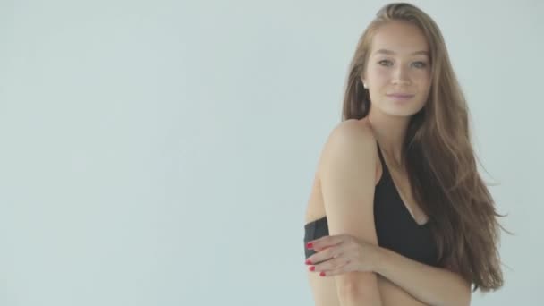 Close-up portrait of a sporty girl with makeup. The girl smiles and laughs, looking at the camera on a white background. — Stock Video