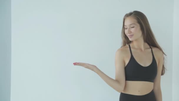 Close-up portrait of a sporty girl with makeup. The girl smiles and laughs, looking at the camera on a white background. — Stock Video