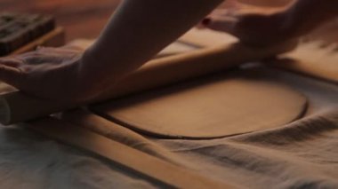 Atölyede kil tabaklar yapma süreci. El yapımı seramiklerden yapılmış dekoratif sofra takımı..
