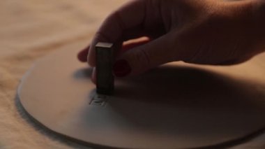 Atölyedeki kil tabaklara harfler basıyorum. El yapımı seramiklerden yapılmış dekoratif sofra takımı..